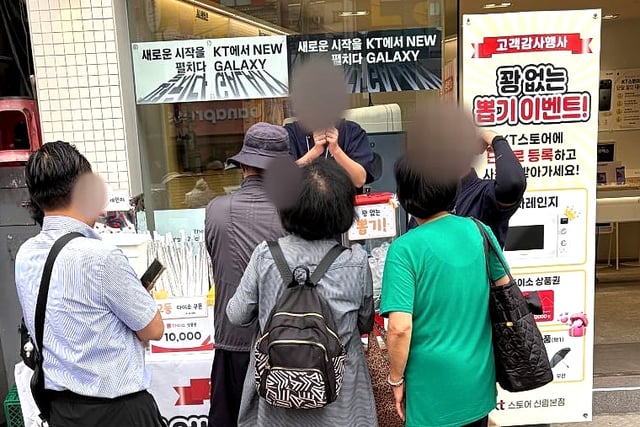 KT스토어 신림본점 직원이 행사 부스에서 참여 방법을 안내하는 모습